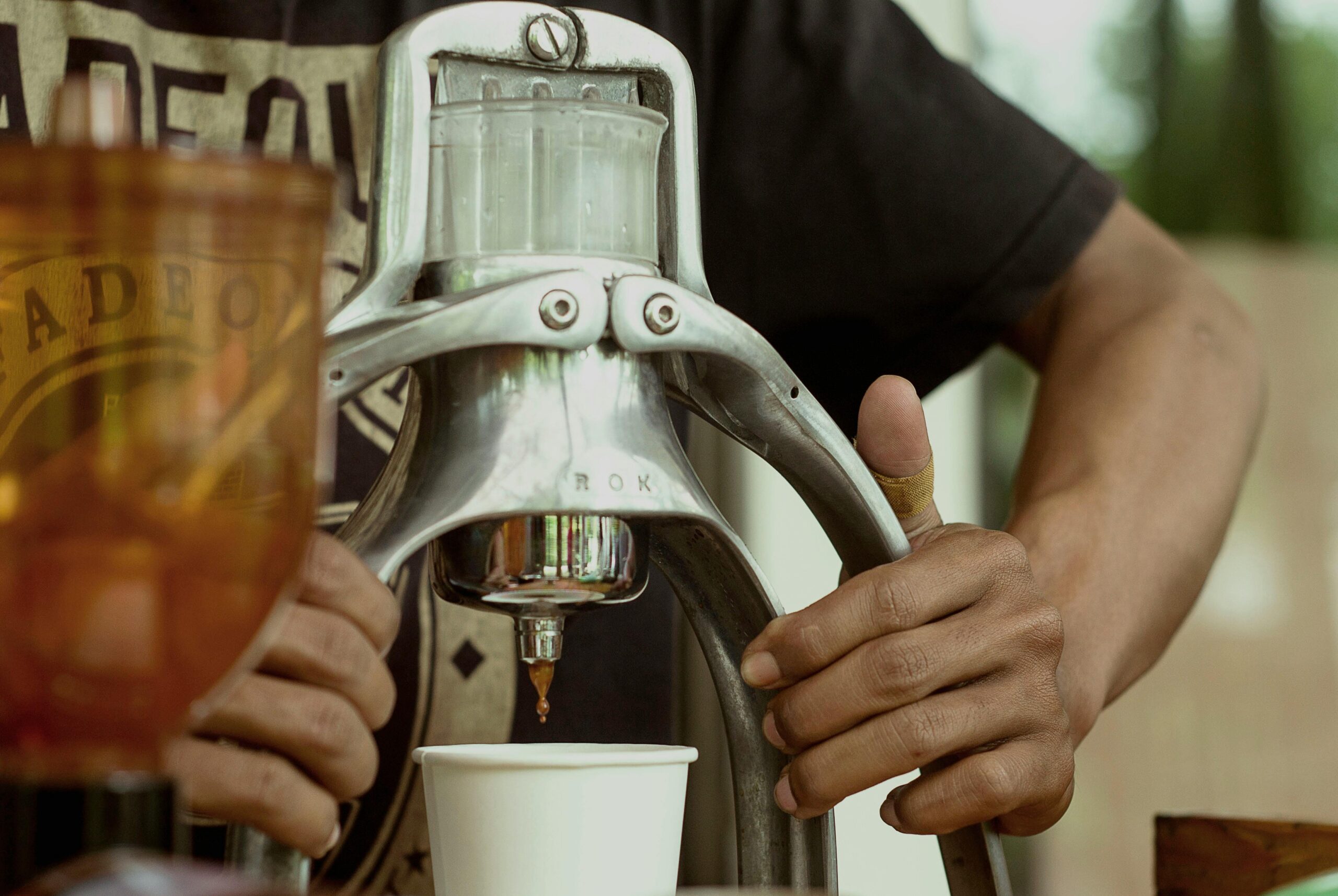 A person frowning at a poorly brewed cup of coffee using a traditional coffee maker