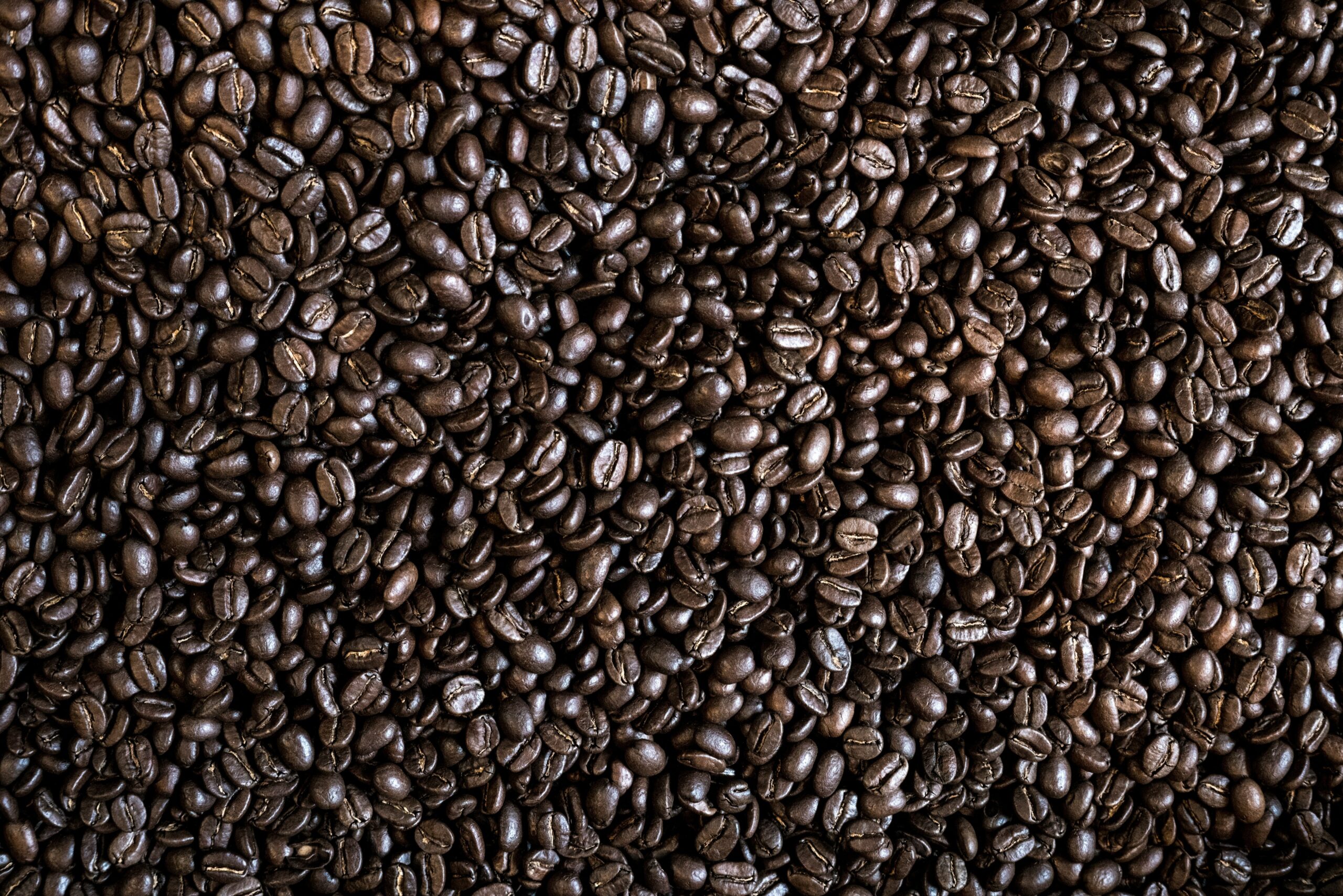 Close-up shot of various premium coffee beans including espresso, light, and medium roasts.