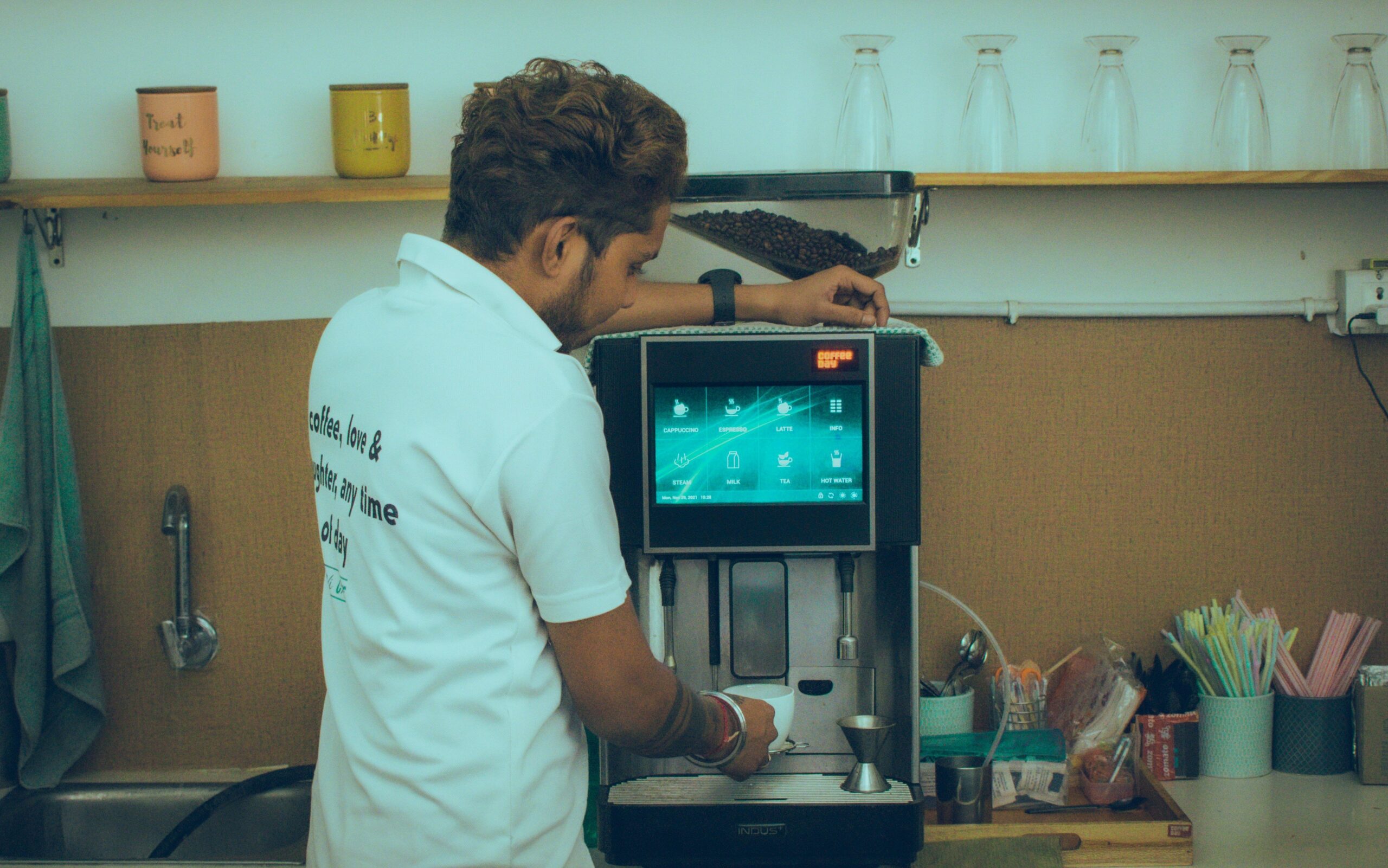A person pouring vinegar solution into a smart coffee maker to clean it.