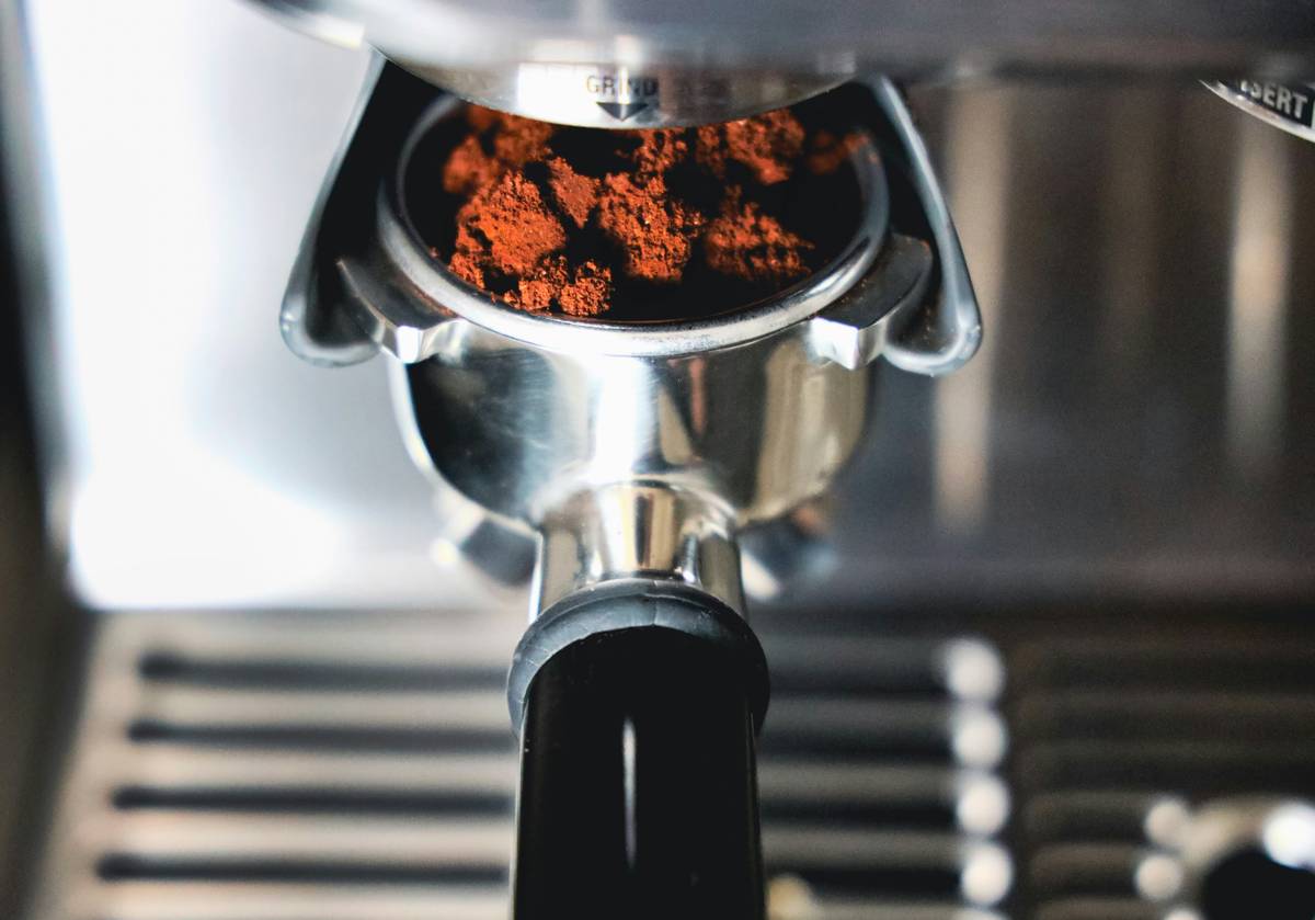 A close-up shot of coffee beans spilling out of a bag onto a wooden table.