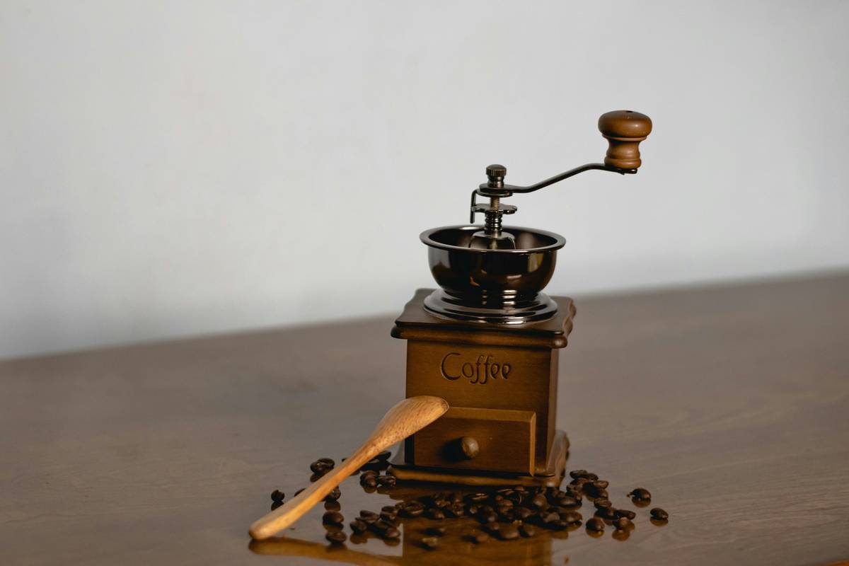 Close-up of someone brushing out coffee particles from a burr grinder.