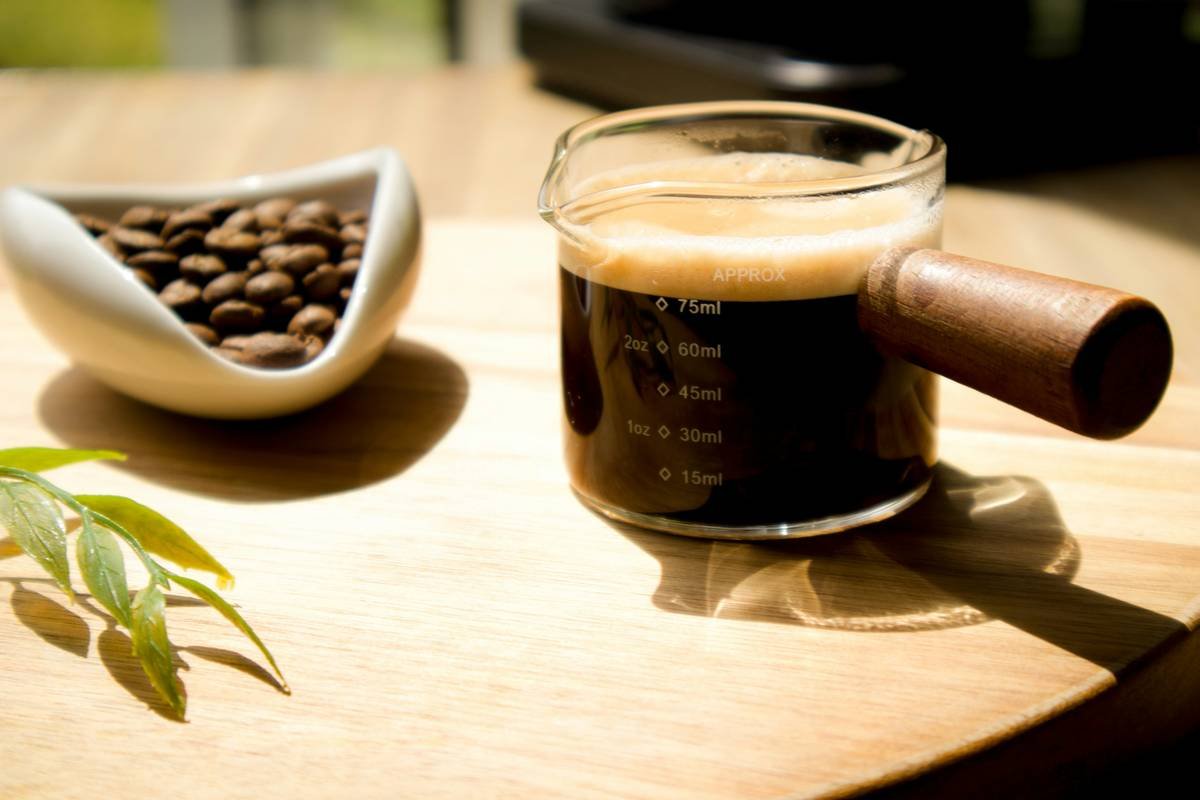 A close-up shot of premium rich coffee beans piled in a wooden bowl.