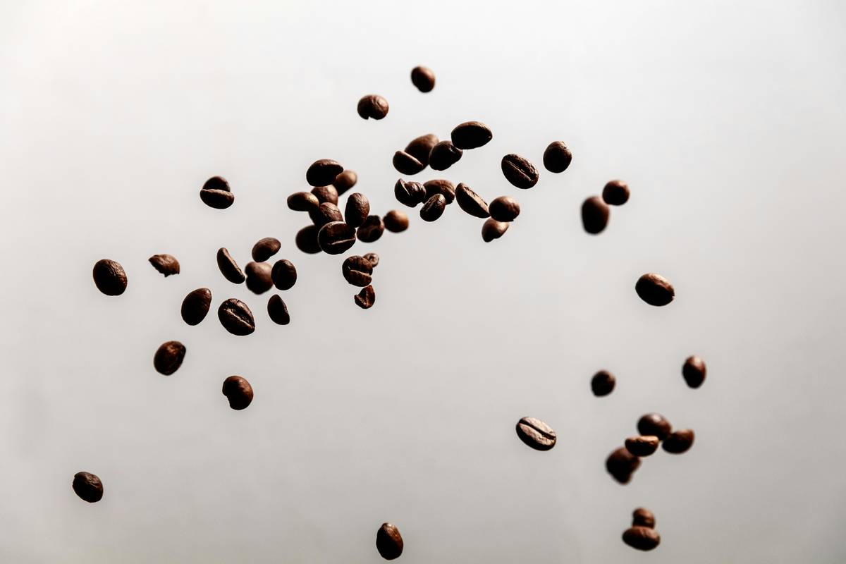 A mug of unappetizing coffee sitting next to spilled grounds