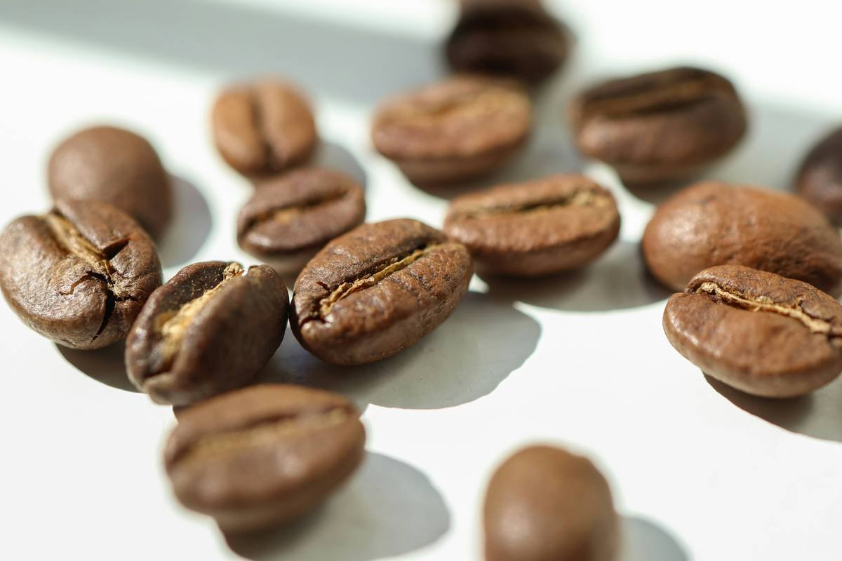 A person holding a mug of coffee made with a smart coffee maker