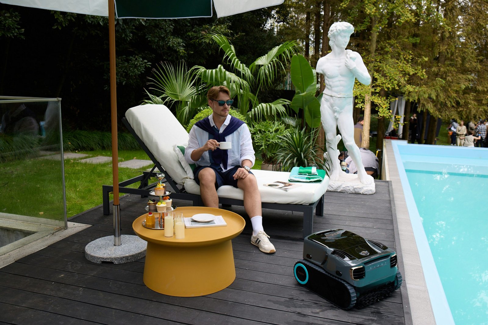 Coffee by the garden pool with Aiper robotic pool cleaner on standby.