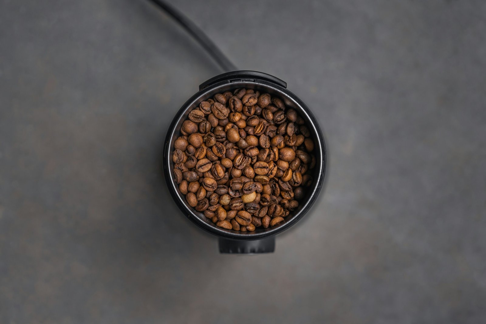 a coffee cup filled with coffee beans on top of a table