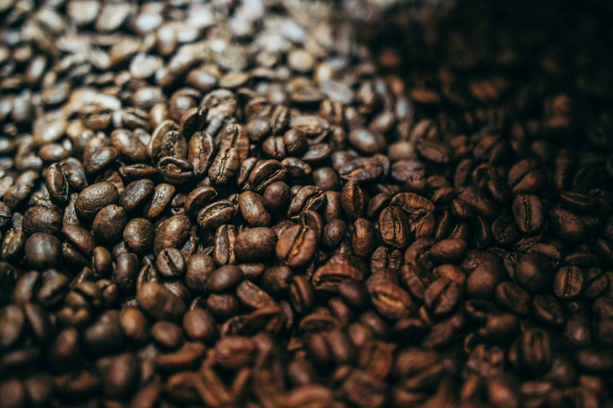 A close-up shot of stale coffee beans scattered on a wooden table.