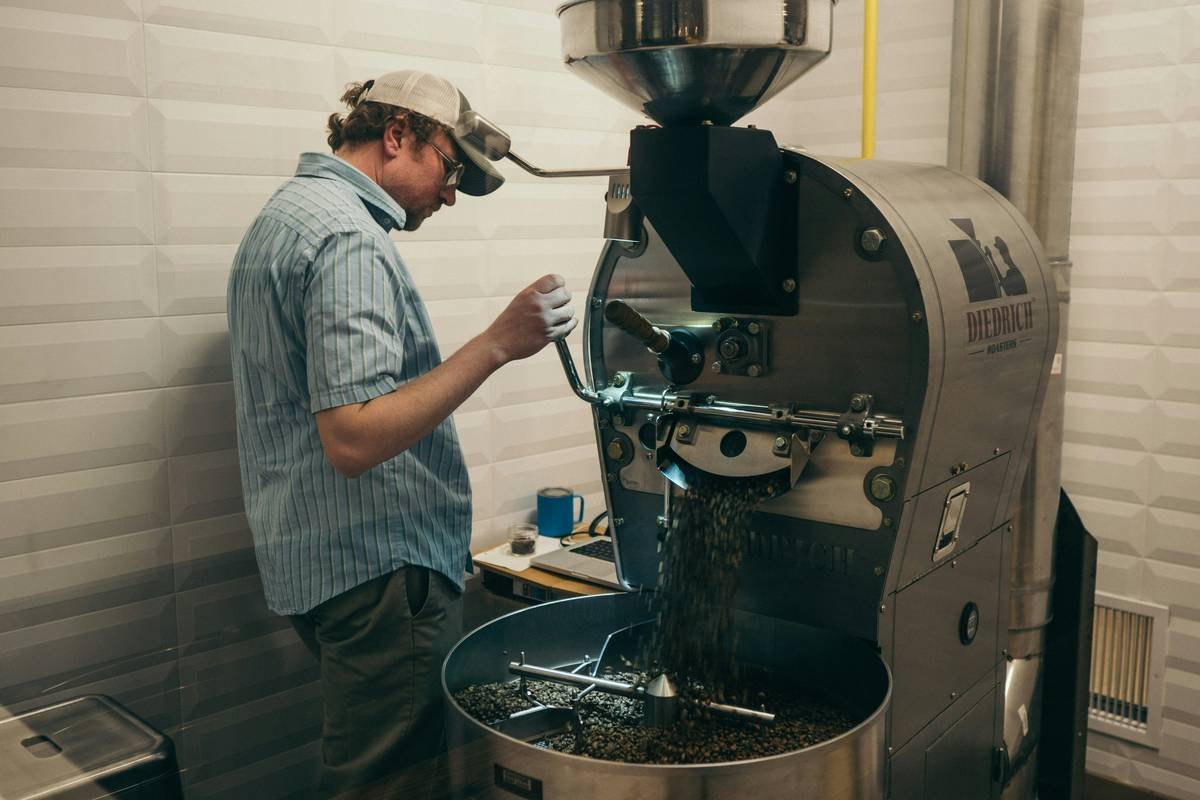 A person cleaning a smart coffee maker with vinegar solution