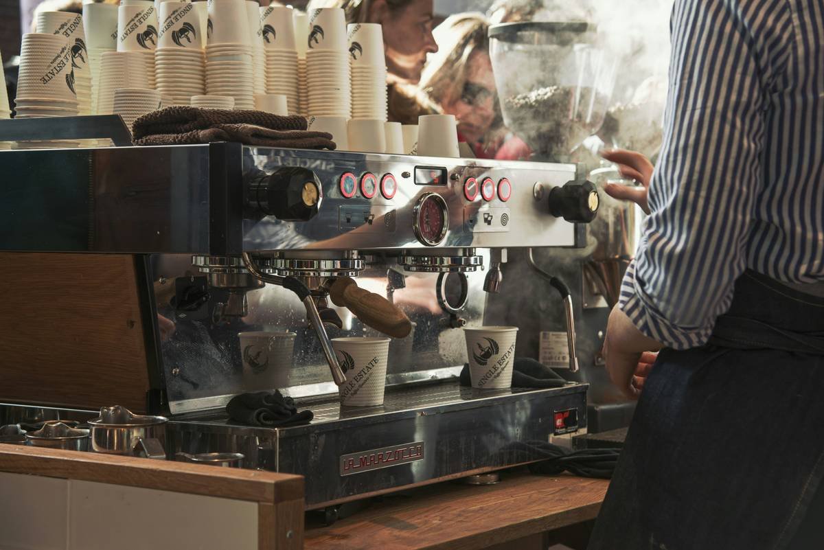 Side-by-side photo: left shows a dark, slimy coffee machine drip tray with visible mold; right shows a spotless stainless steel tray after proper cleaning
